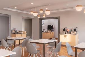 a restaurant with tables and chairs and a kitchen at TownePlace Suites by Marriott Wareham Buzzards Bay in Wareham