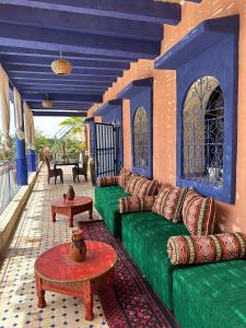 a living room with a green couch and tables at villa Oasis Rouge Sable in Marrakesh