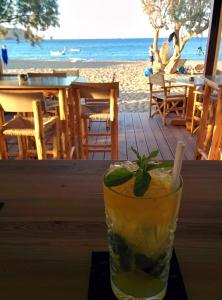 a drink sitting on a table next to the beach at Surf Beach Apartments in Palekastron