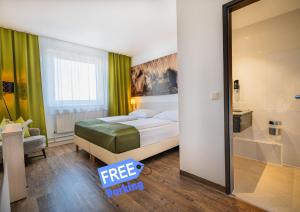 Un dormitorio con una cama y una puerta corrediza de vidrio. en LifeHotel Vienna Airport, en Fischamend Dorf