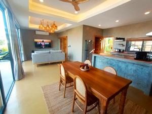 a kitchen and dining room with a wooden table and chairs at Villa La Quartz Seaview 2BR in Chaweng Noi Beach