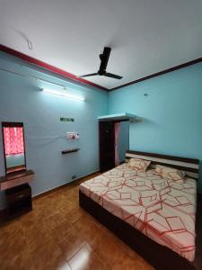 a bedroom with a bed and a blue wall at Holiday Home Madurai CS Nagar - GF in Madurai +20 photos