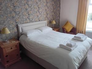 a bedroom with a white bed with towels on it at Foresters Guest House Ltd in Crook