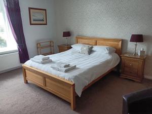 a bedroom with a large bed with towels on it at Foresters Guest House Ltd in Crook