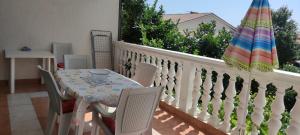 a balcony with a table and chairs and an umbrella at Apartments Tessa 77 in Medulin