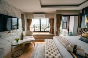 a bedroom with a large bed and a chair and a window at Bestier Hotel Hatyai in Hat Yai