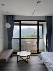 una camera con letto, tavolo e finestra di Yong Li Hotel a Gukeng