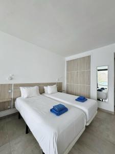 a large white bed with two blue towels on it at Sea View Cura Marina 415 in Playa del Cura +13 photos
