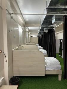 SatnaRadha Residency的绿色地毯的房间里一排床 更多37张照片