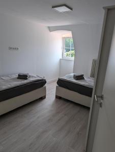 two beds in a small room with a window at Wohnung am Kasinopark in Georgsmarienhütte