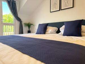a bedroom with a bed with blue pillows and a window at New! Central Penthouse, King Size Bed & Balconies in Maidstone