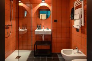 ein Badezimmer mit Waschbecken, Toilette und Spiegel in der Unterkunft CX Milan Bicocca in Mailand
