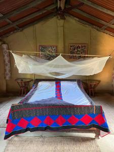 ein Bett in einem Zelt mit Krawatte drauf in der Unterkunft Bardia dolphin home in Bhurkīā