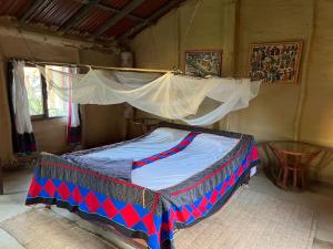 ein Bett mit Baldachin in einem Zimmer in der Unterkunft Bardia dolphin home in Bhurkīā