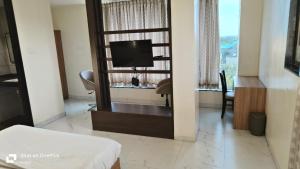 a hotel room with a tv and a mirror at ID Square residency Parbhani in Parbhani