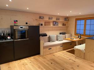 a kitchen with a couch in the middle of a room at Chalet La Montanara in Bettmeralp