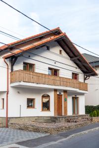 a white house with a balcony on top of it at Casa Simona Bran in Bran