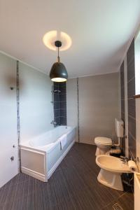 a bathroom with a tub and a toilet and a sink at Casa Simona Bran in Bran