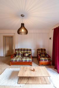 a living room with two couches and a table at Casa Simona Bran in Bran