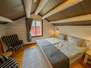 a bedroom with a bed and a chair in a room at Stugan in Ekshärad +3 photos