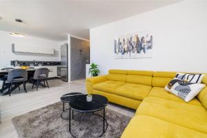 a living room with a yellow couch and a table at Klara in Crikvenica