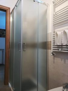 una doccia con una porta in vetro in un bagno di Alloggio turistico centro storico di Manziana a Manziana