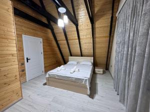 a bedroom with a bed in a wooden room at Aframe Park Qebele in Gabala