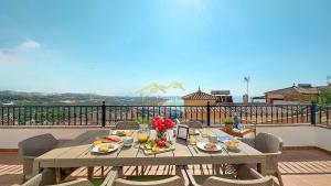 un tavolo con cibo e fiori in cima a un balcone di Balcón del Mar a Nerja