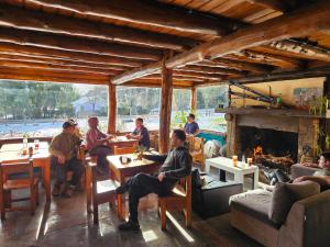 a group of people sitting at tables in a restaurant at Hostel Capsula Refugio Oeste in San Carlos de Bariloche