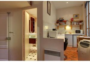 a room with a kitchen with a counter and a kitchen sidx sidx sidx at Studio convivial à Paris, 30 m² avec vue sur la ville in Paris