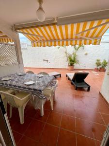 a patio with a table and chairs in a room at Gladiolos San Agustin Beach in San Agustin