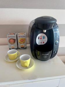 a coffee maker and two cups on a counter at Gladiolos San Agustin Beach in San Agustin