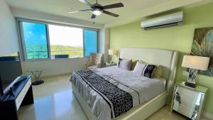 a bedroom with a bed and a ceiling fan at Apartment with Spectacular Ocean Jungle Views in Playa Bonita Village +28 photos