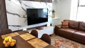 un salon avec un canapé et une télévision dans l'établissement 23 Innes Street Apartment, à Inverness