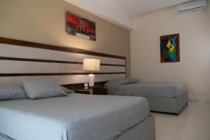 a hotel room with two beds and a lamp at Infinity Suites doble room 102 in Cancún