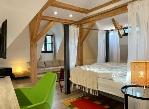 a bedroom with a bed and a green chair at Boutique Hotel Barvírna in Český Krumlov