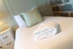 a pile of towels sitting on top of a bed at Eden View Estate - Clubhouse Cottage in St. Andrews
