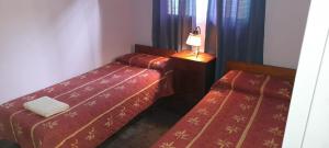 een kamer met twee bedden en een lamp op een tafel bij Cabaña La Cumbre Palermo in La Cumbre