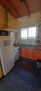 een keuken met een witte koelkast en een fornuis bij Cabaña La Cumbre Palermo in La Cumbre