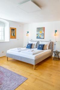 a large bed in a white room with blue pillows at SMS-Homes I Auszeit in der Altstadt in Landsberg am Lech