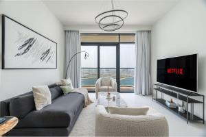 un salon avec un canapé et une télévision dans l'établissement GuestReady - Elegant stay with Palm Jumeirah view, à Dubaï