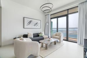 un salon avec un canapé, des chaises et une table dans l'établissement GuestReady - Elegant stay with Palm Jumeirah view, à Dubaï