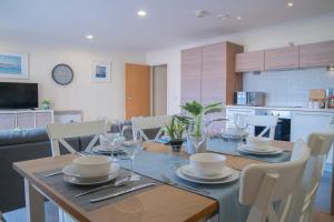 a dining room table with plates and glasses on it at Steps away from New Street Station & 2 Beds & 2 Baths Flat at City Center in Birmingham