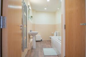 a bathroom with a sink and a toilet and a tub at Steps away from New Street Station & 2 Beds & 2 Baths Flat at City Center in Birmingham