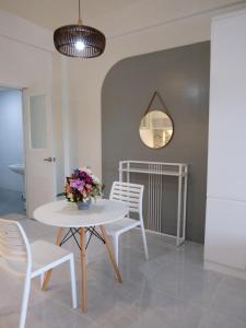 a white table and chairs with a vase of flowers on it at Karas Pension House East in Tuguegarao City