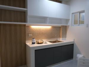 a kitchen with a sink and a counter top at Karas Pension House East in Tuguegarao City +11 photos
