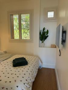 a bedroom with a bed with a black bag on it at Le balcon de la Rade in Cassis