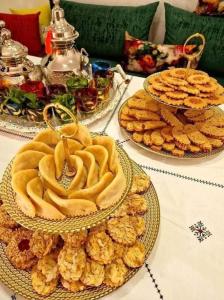 a table with three plates of food and cookies at Nabiloc Apart Hotel - Centre Ville in Fez