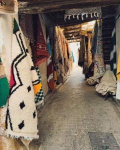 an aisle of a market with blankets and scarves at Nabiloc Apart Hotel - Centre Ville in Fez +11 photos