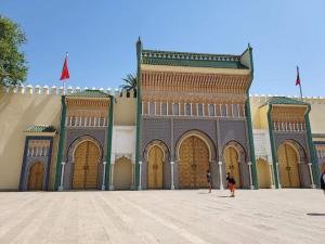 a large building with large doors and a person standing in front at Nabiloc Apart Hotel - Centre Ville in Fez